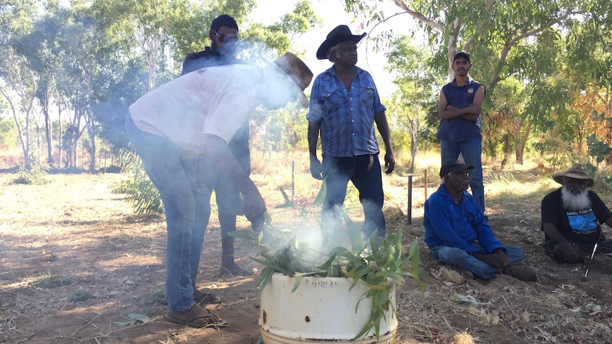 Indigenous elders performing a smoking ceremony at the Fitzroy River cemetery.