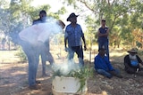 Indigenous elders performing a smoking ceremony at the Fitzroy River cemetery.