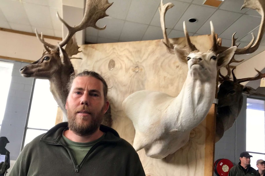 Tasmanian taxidermist Neville Bannister stands in front of his wares