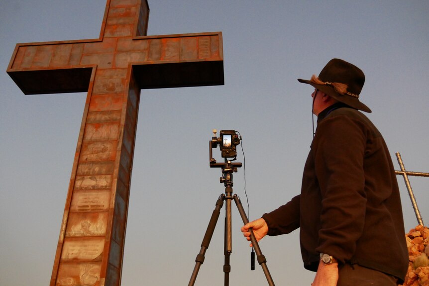 El fotógrafo Ken Duncan fotografiando una cruz gigante