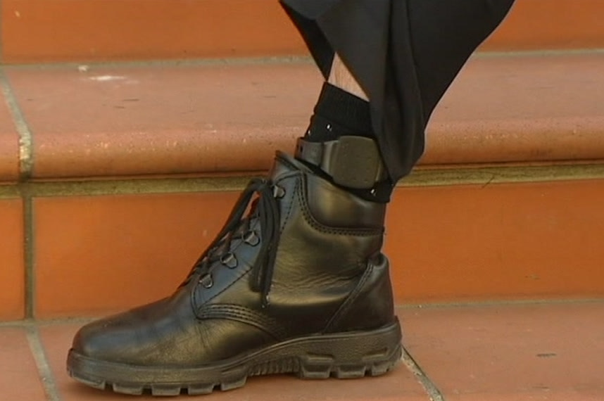 A police GPS tracking device is seen on a suspect's ankle.