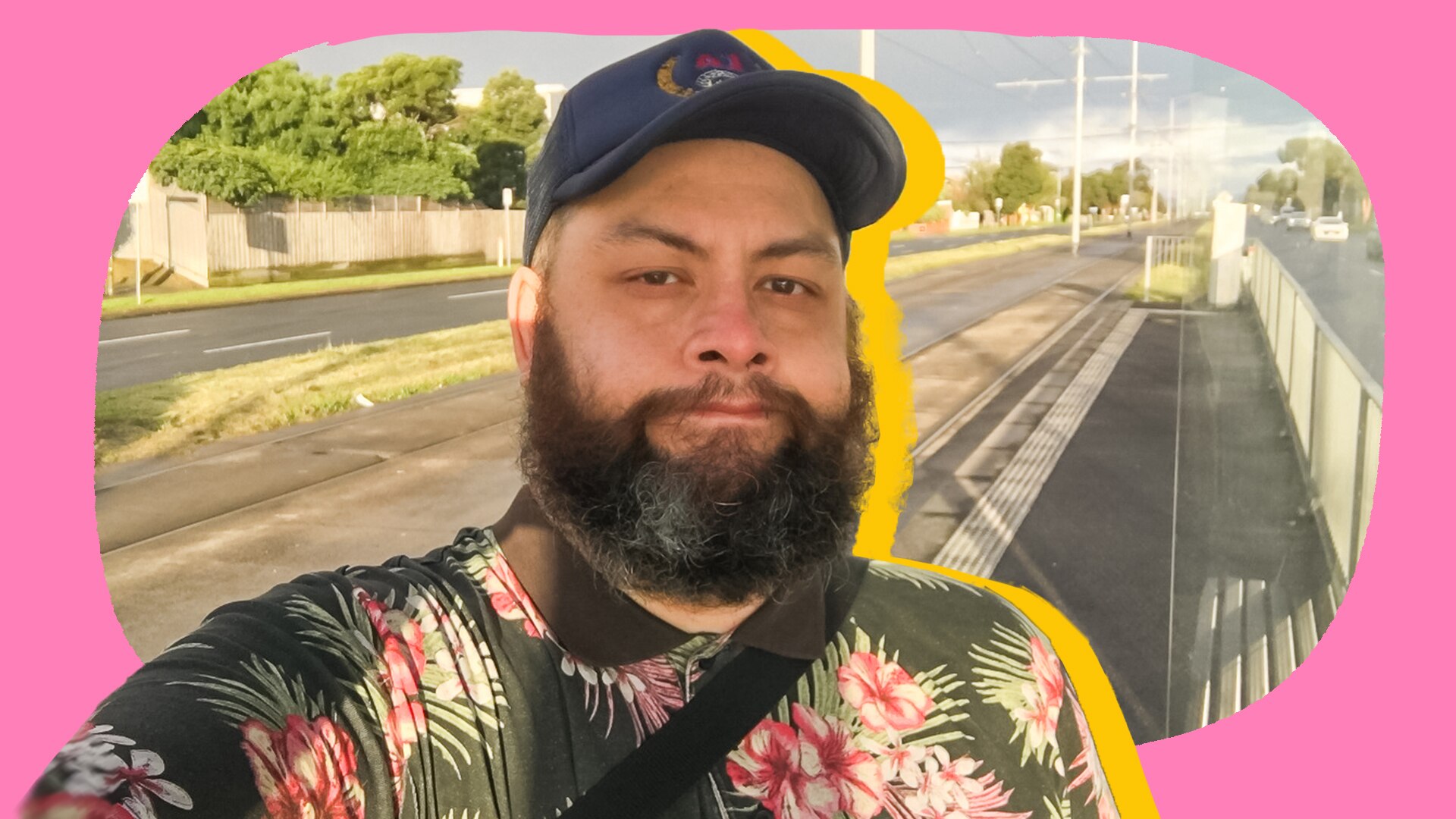 Michael stands outside taking a selfie.