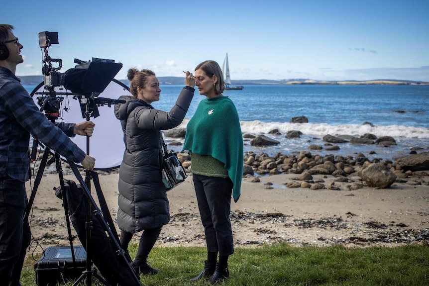 Cassy O'Connor has her makeup done at the beach.