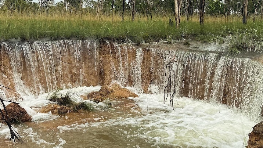 water pouring into a ditch in a remote community