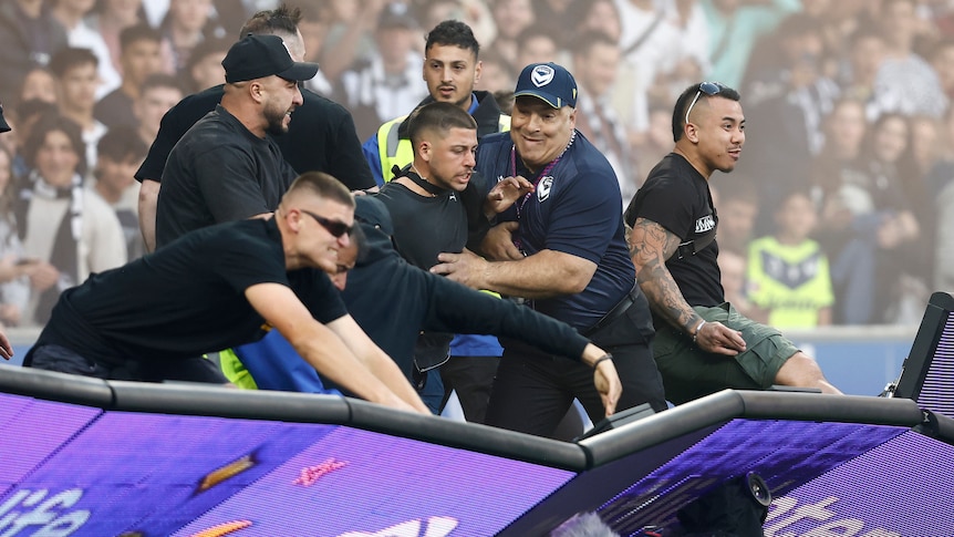 Fans storm the pitch in protest during the round eight A-League Men's match between Melbourne City and Melbourne Victory.
