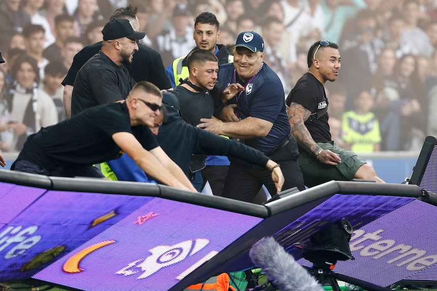 Fans storm the pitch in protest during the round eight A-League Men's match between Melbourne City and Melbourne Victory.