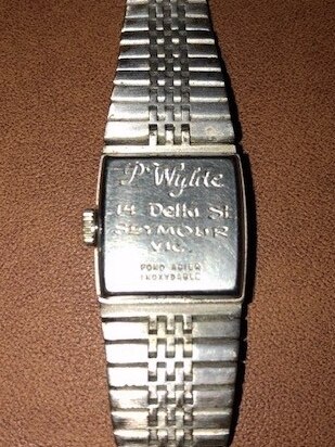 Photo of back of a silver watch with name (P. Wylde) and home address in Seymour inscribed.
