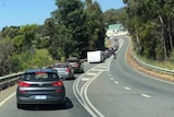 A long line of cars is seen over a dashboard.