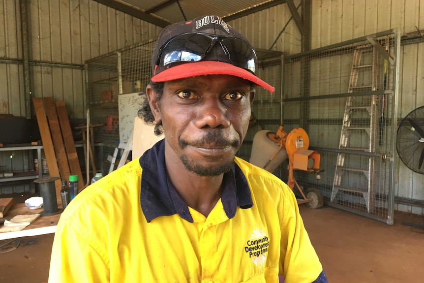 man looks into camera in workshop