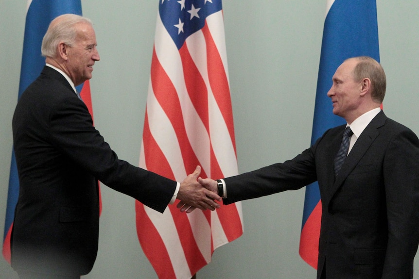 Президент США Байден пожимает руку президенту России Путину на встрече в Москве в 2011 году.