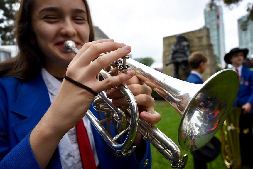 A girl plays the bugle during the Melbourne Anzac Day march