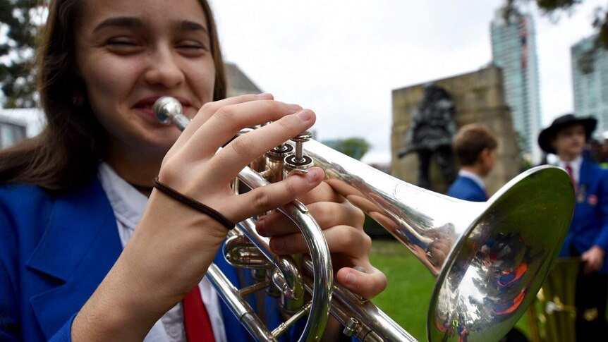 A girl plays the bugle during the Melbourne Anzac Day march