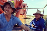 David Pocock (L) and farmer Rick Laird (R) sit on mining equipment