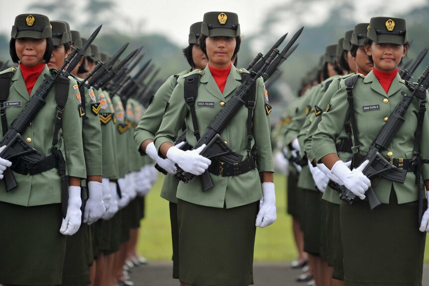Female Indonesian soldiers stand in formation during a military ceremony