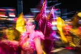Photo is captured with a slow shutter speed and shows a woman in a butterfly outfit