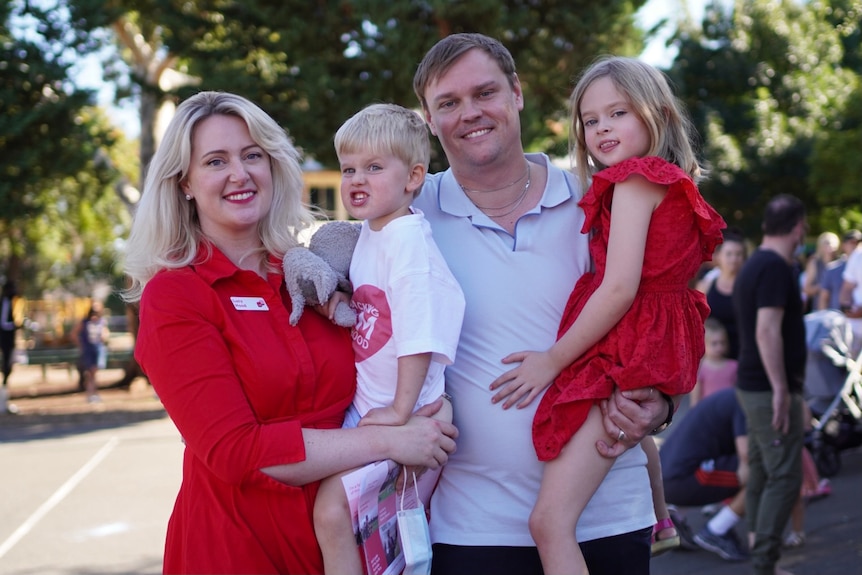 A man and a woman holding a boy and a girl