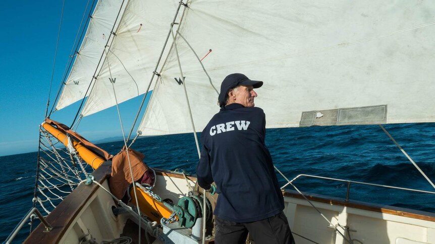 Volunteer Mark Gooley adjusting sails near bow of Julie Burgess