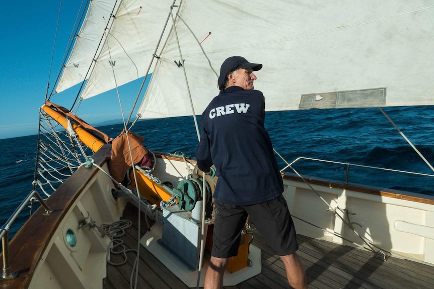 Volunteer Mark Gooley adjusting sails near bow of Julie Burgess