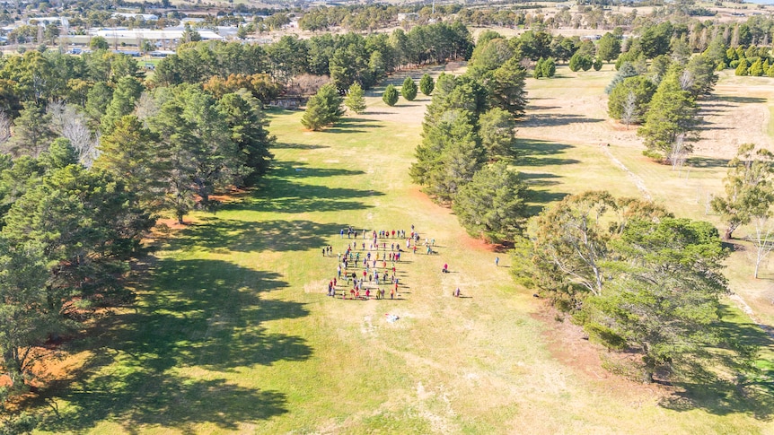 Aerial of golf course with a group of people standing together 