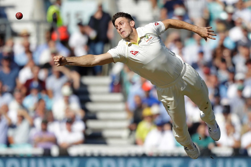 Australia bowler Mitch Marsh dives in an attempt to rein in a cricket ball.
