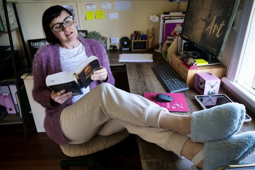 woman wearing slippers puts feet on desk
