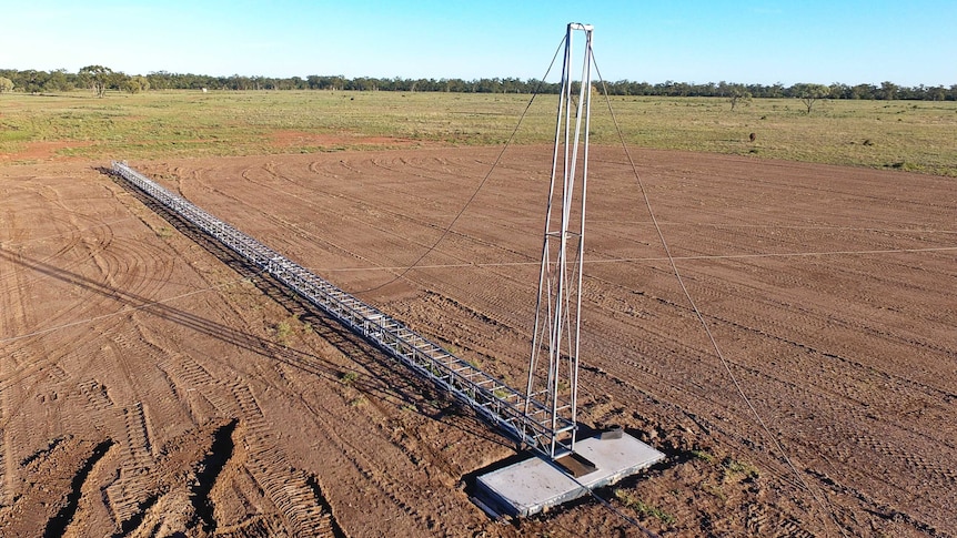 An aerial view of a wireless internet tower lying in a paddock, ready to be erected.