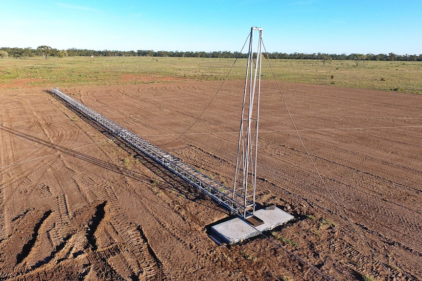 An aerial view of a wireless internet tower lying in a paddock, ready to be erected.