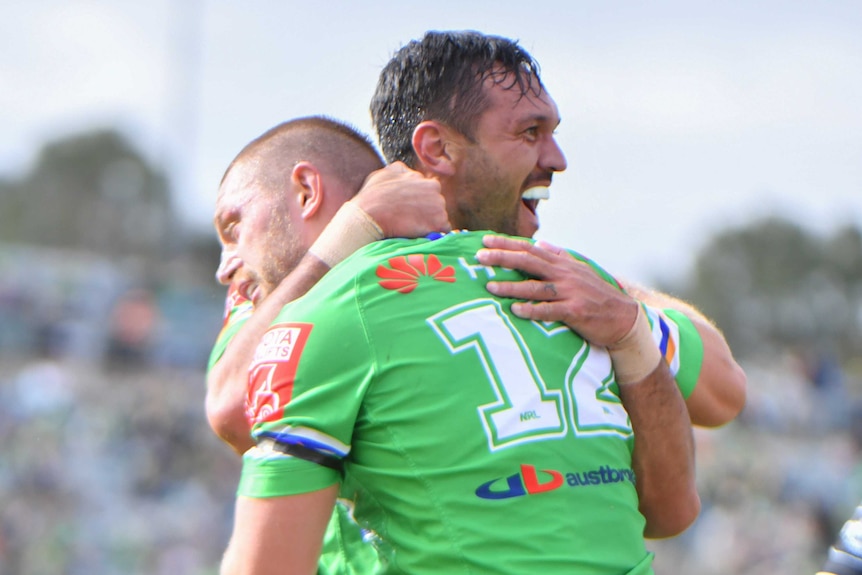 Canberra Raiders players Elliott Whitehead and Jordan Rapana hug after an NRL try against Wests Tigers.