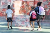 A family walking at a primary school with graphic depictions of the COVID virus on top.