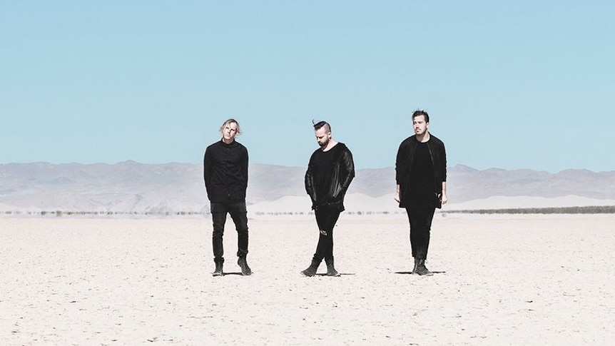 rufus du sol standing in the desert all wearing black