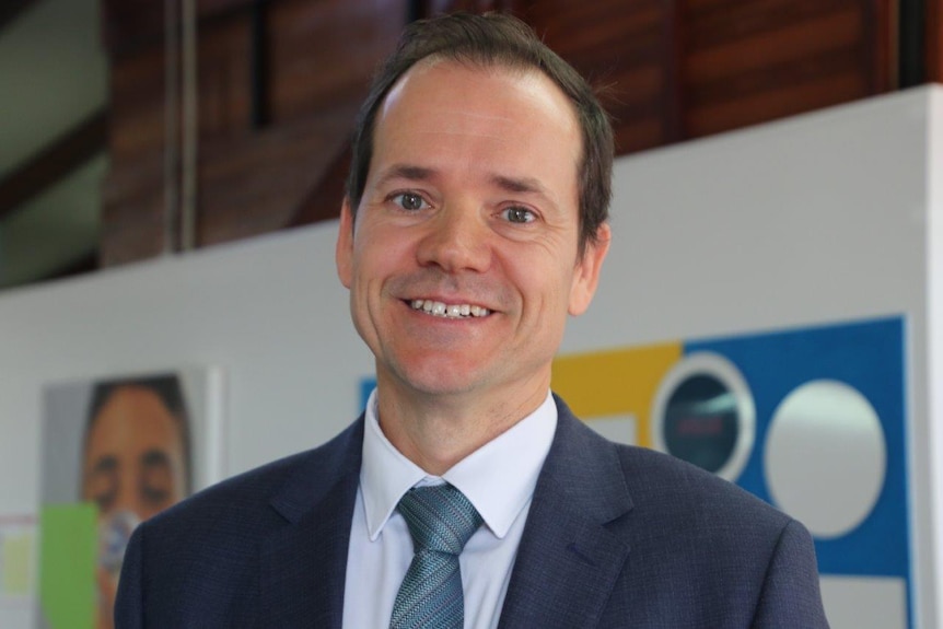 A close up of Matt Byrne, smiling into the camera, standing in a classroom.