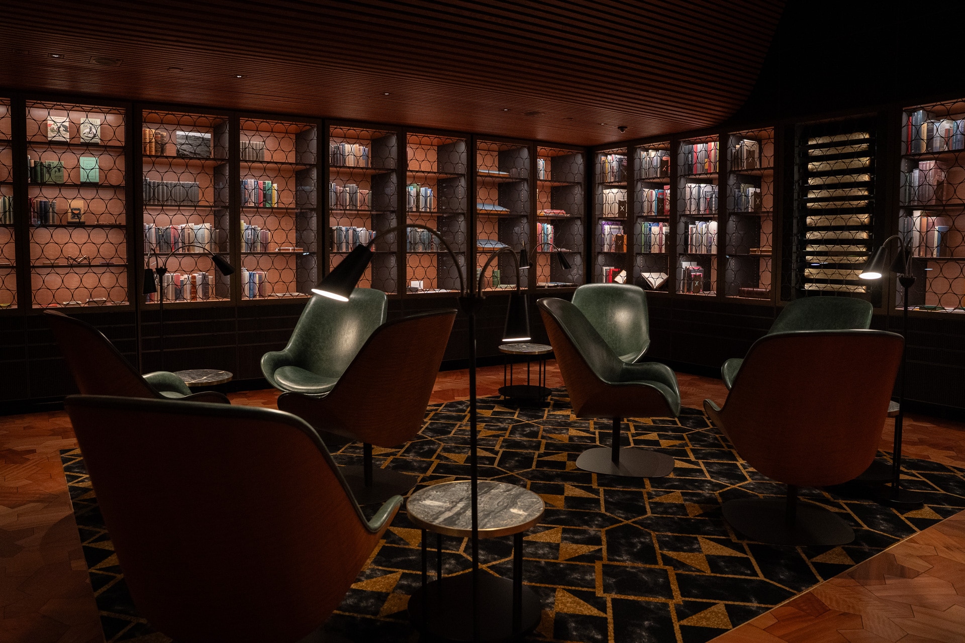 Chairs, lamps and tables in a dark reading room of a library.
