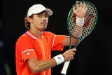 Alex de Minaur claps his racquet
