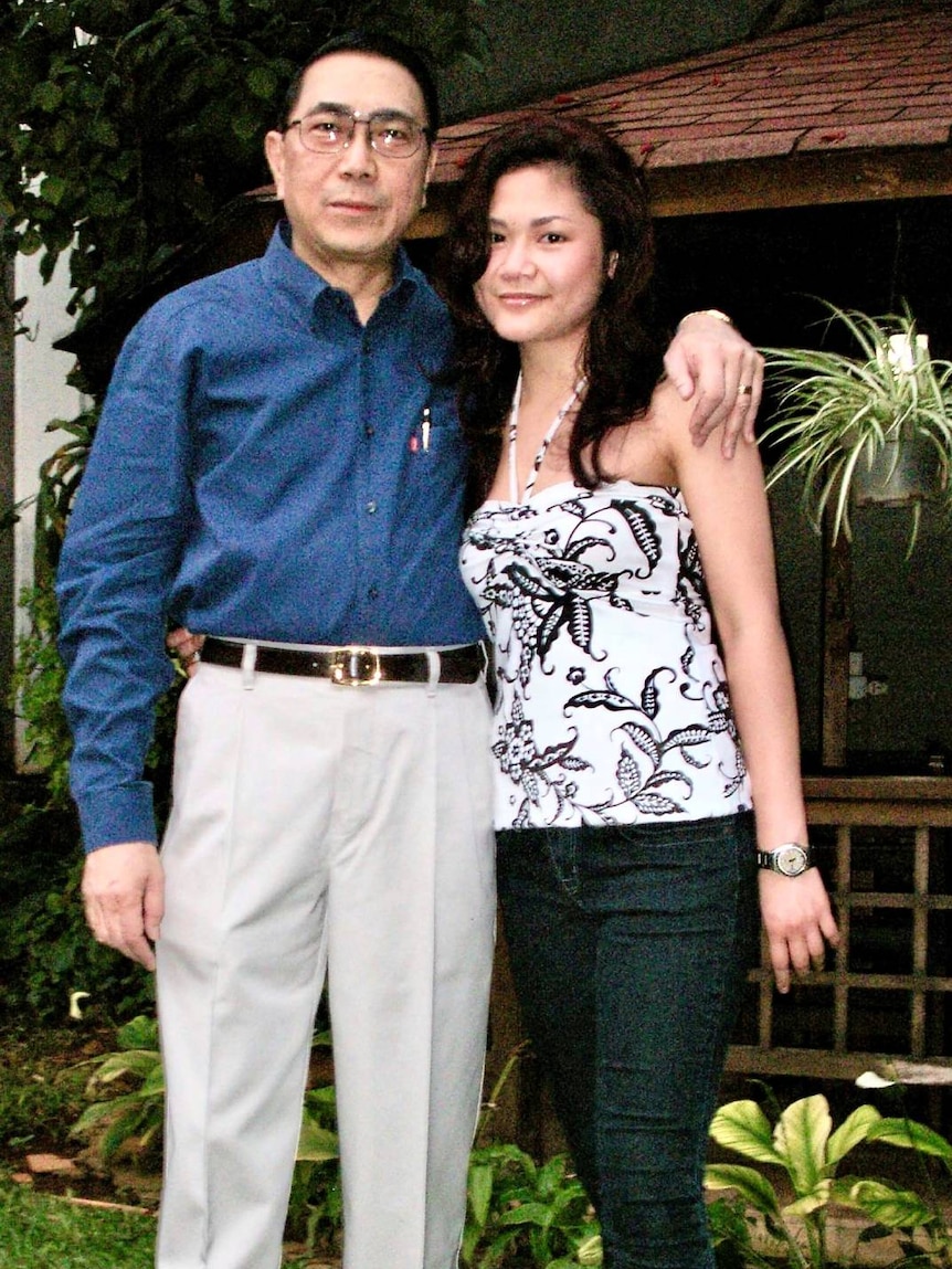 A man stands with his arm around his daughter.