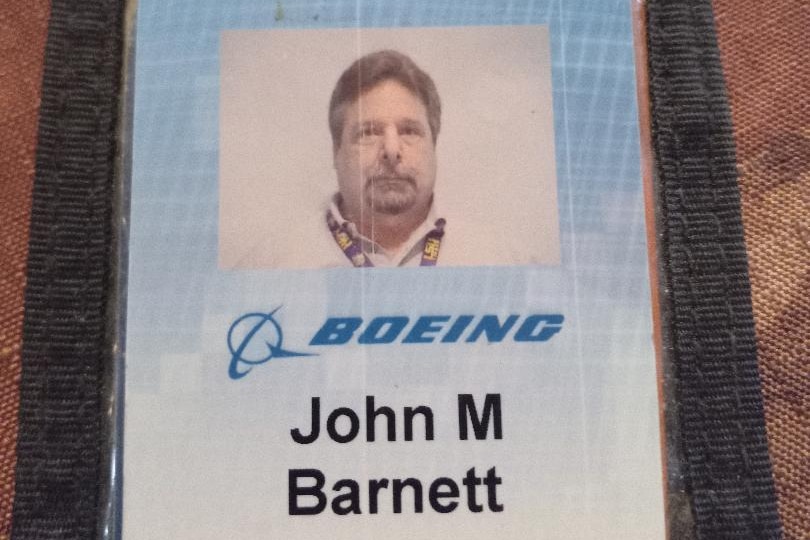 Una tarjeta de identificación de color azul cielo, del tamaño de una tarjeta de crédito, con una fotografía de un hombre mayor, su nombre completo y el logotipo de Boeing.