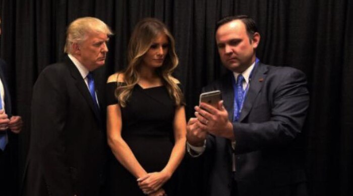 US President Donald Trump and his family look at social media director Dan Scavino's mobile phone.