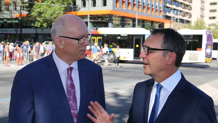 Steven Marshall and David Pisoni smile as they talk on a street in Adelaide.