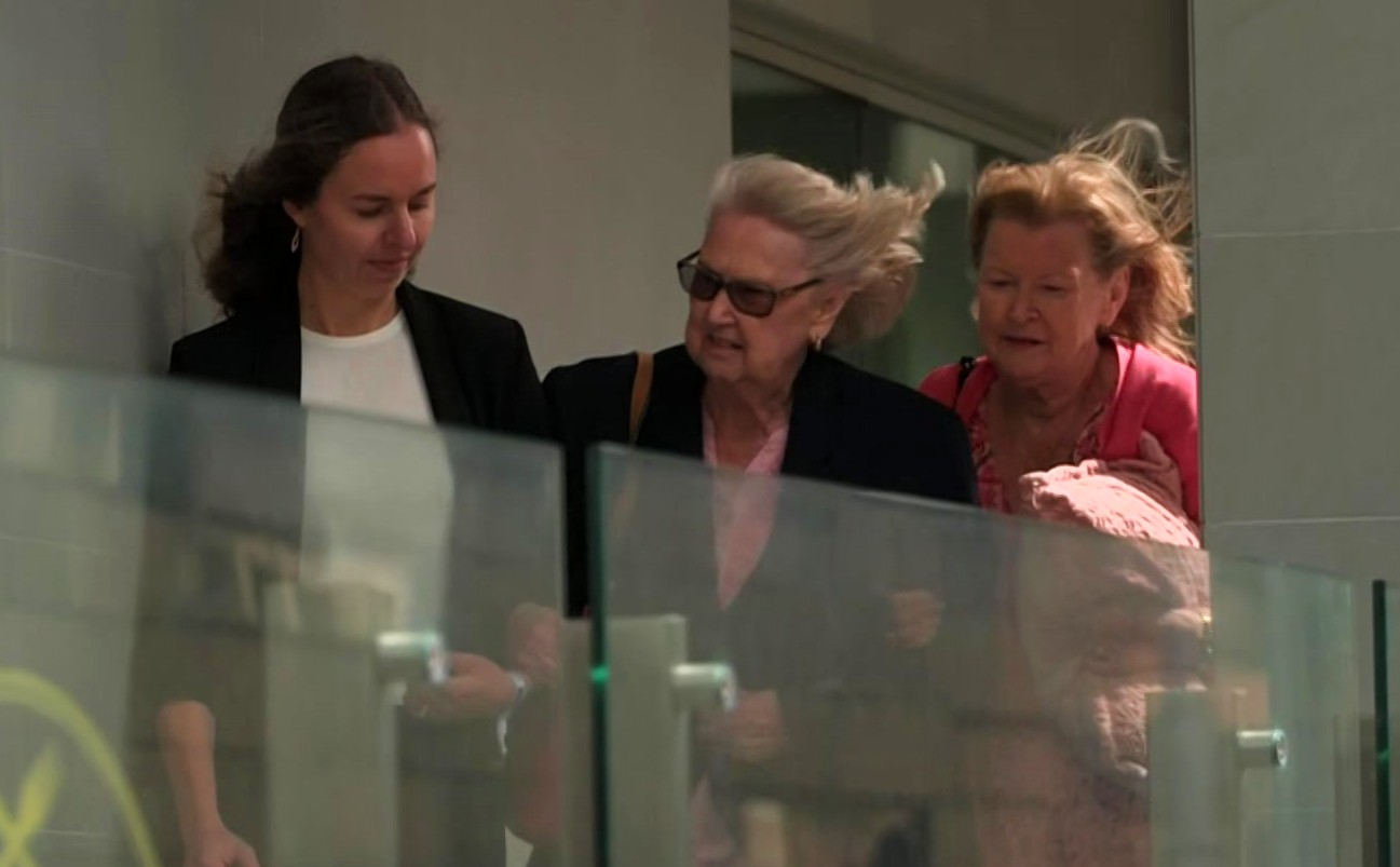 O cabelo de Helen Cable está balançando ao vento enquanto ela sai da quadra entre duas outras mulheres