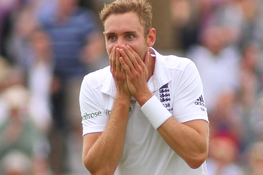 Stuart Broad covers his mouth with his hands and has his eyes wide open