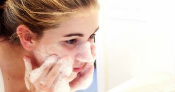 A woman washes her face.