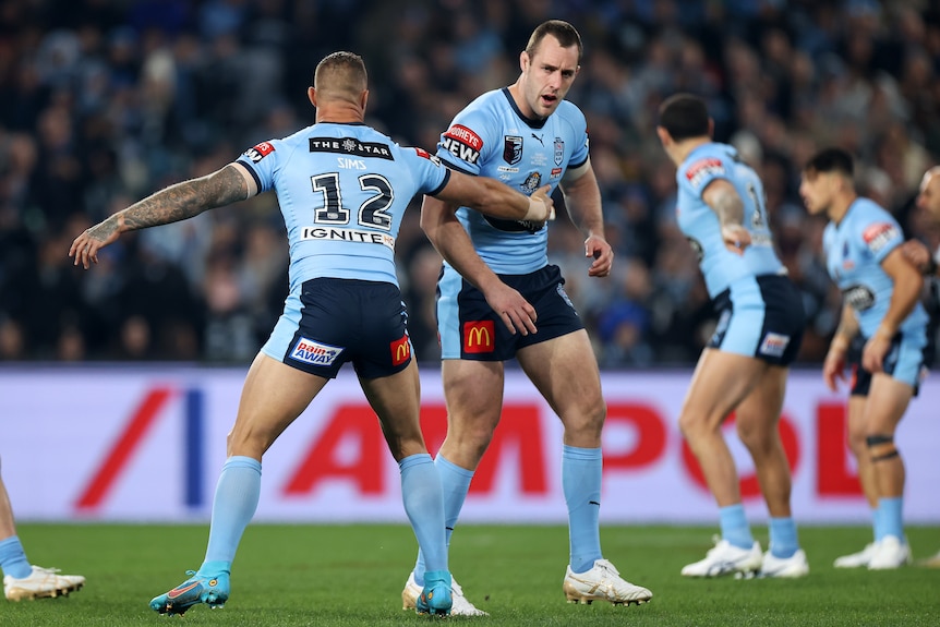 Tariq Sims holds up NSW Blues teammate Isaah Yeo after the first tackle of State of Origin I.