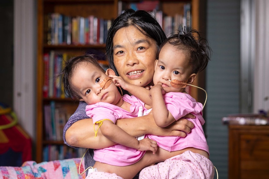 Mother Bhumchu Zangmo holds conjoined twins Nima and Dawa.