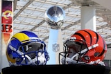 Two helmets in the colours of the Los Angeles Rams and Cincinnati Bengals sit either side of the trophy ahead of Super Bowl LVI.