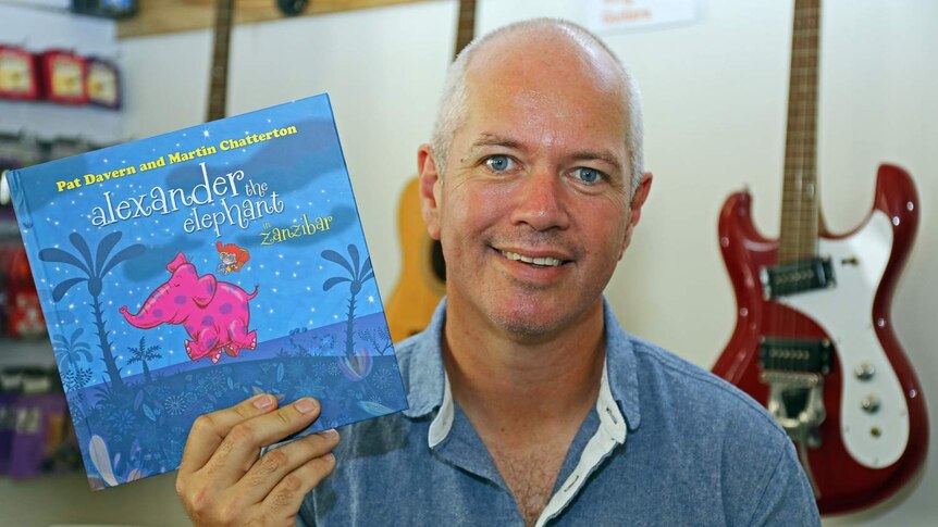 Grinspoon guitarist Pat Davern holds up his new children's book Alexander the Elephant in Zanzibar