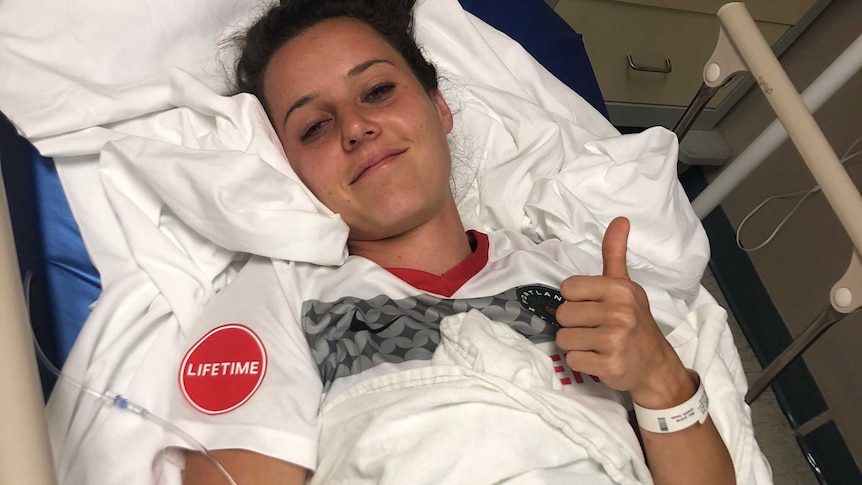 Hayley Raso gives the thumbs up after receiving treatment for a broken back, still wearing her Portland Thorns strip