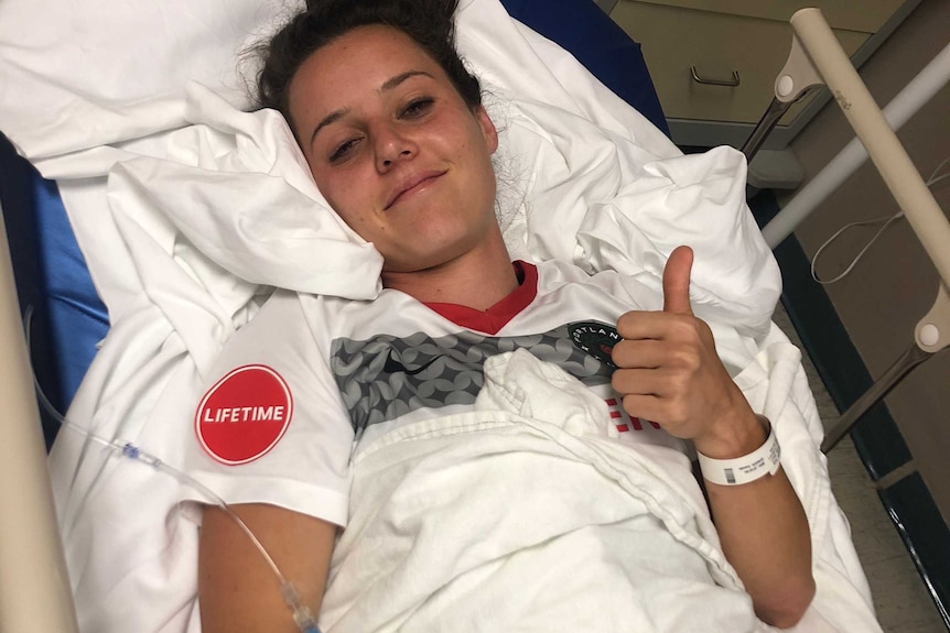 Hayley Raso gives the thumbs up after receiving treatment for a broken back, still wearing her Portland Thorns strip