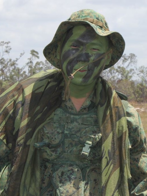Soldier in uniform with camouflage face paint