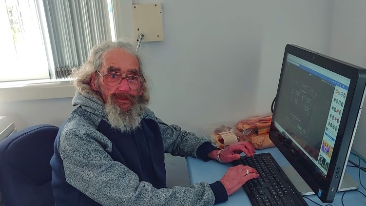 Wally Douglass sits at computer