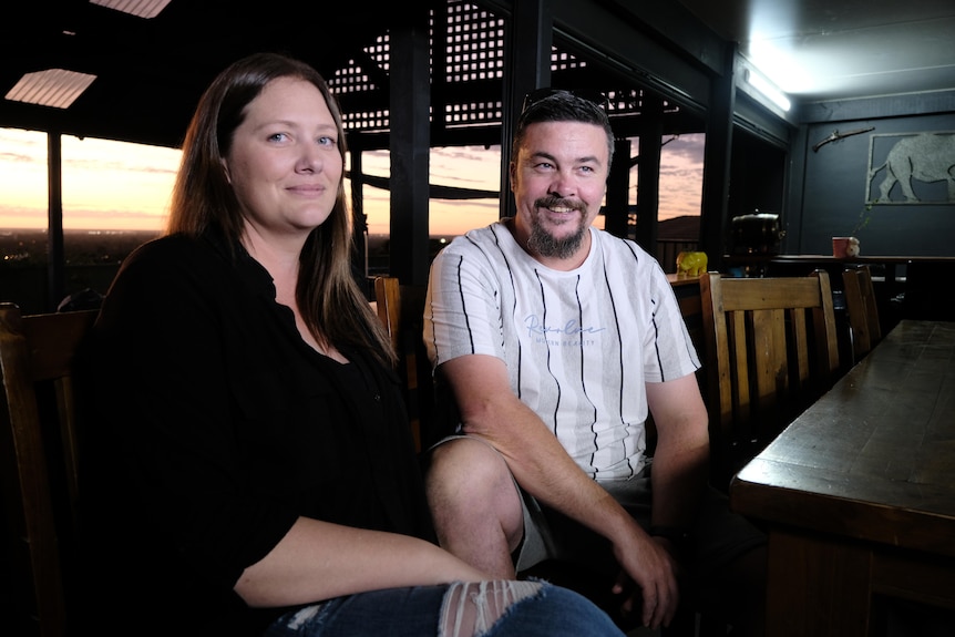 A woman wearing black and a man wearing white sitting at a table