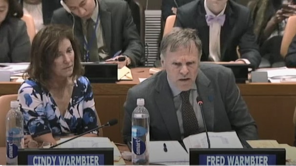 Cindy and Fred Warmbier sit next to each other at a table with microphones